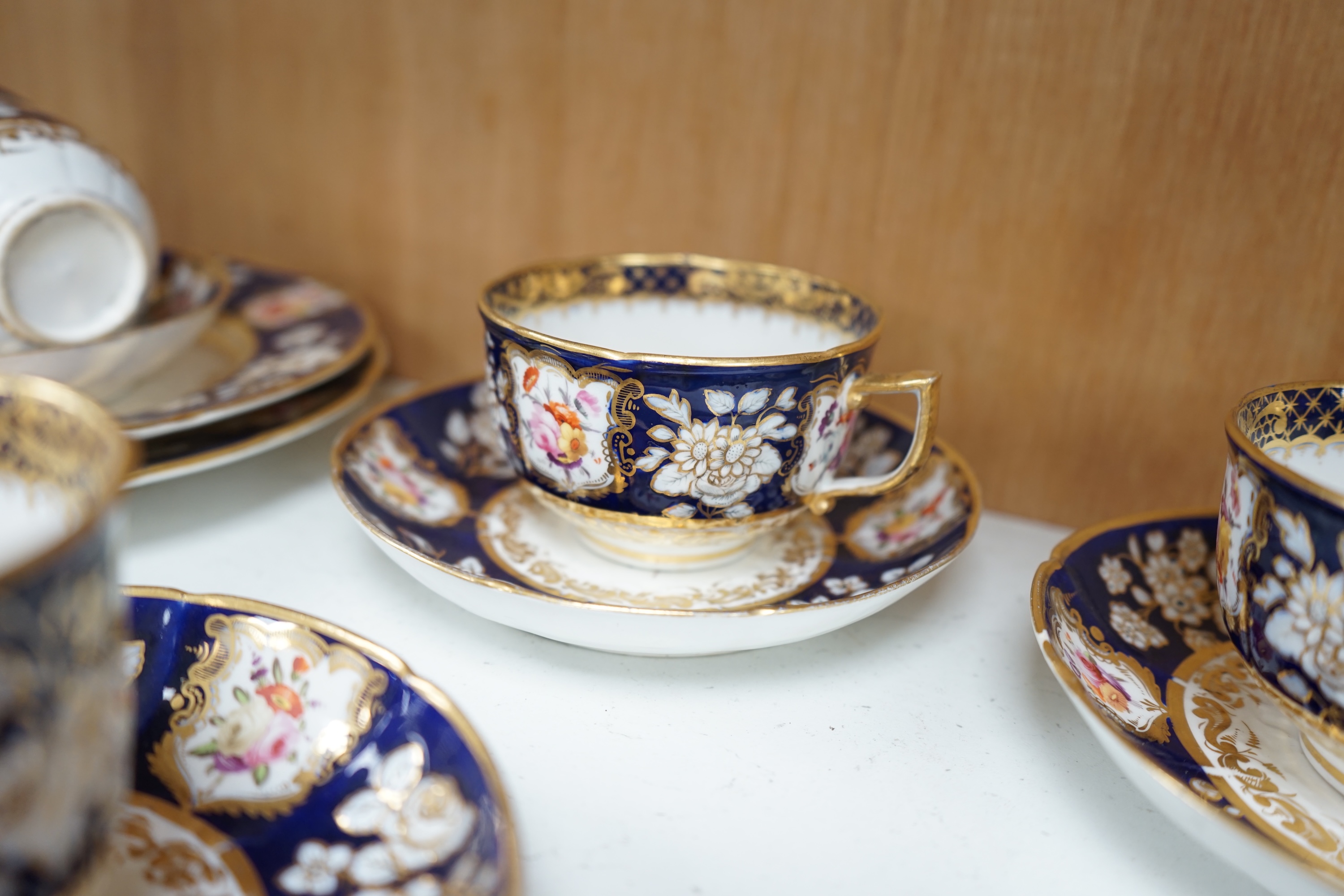 An early 19th century English porcelain tea service, possibly Coalport, moulded in low relief with floral reserves and cobalt blue border. Condition - varies